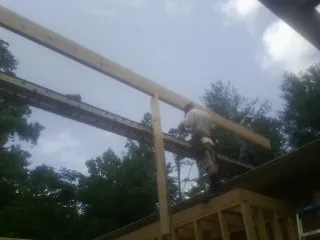 Carpenter setting a ridge beam over a new addition frame — Ice Dam Removal by Roofing Brothers in Tiverton