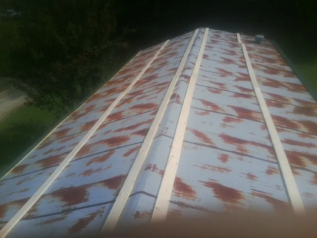 Rusted metal roof panels with new wood purlins before replacement — Storm Damage Roof Repair in Tiverton by Roofing Brothers