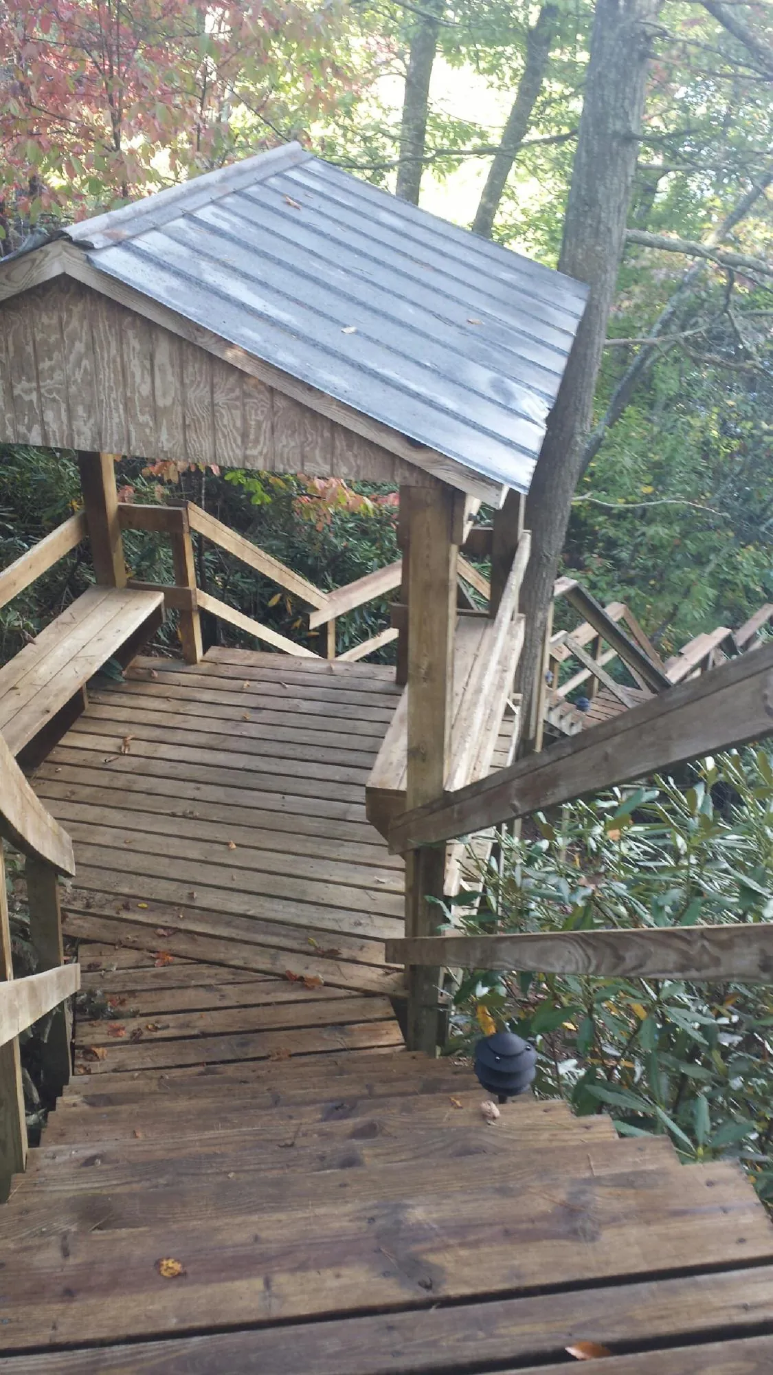 Metal roofed shelter over wooden steps on a wooded walkway — Skylight Repair & Installation work by our crew in Tiverton