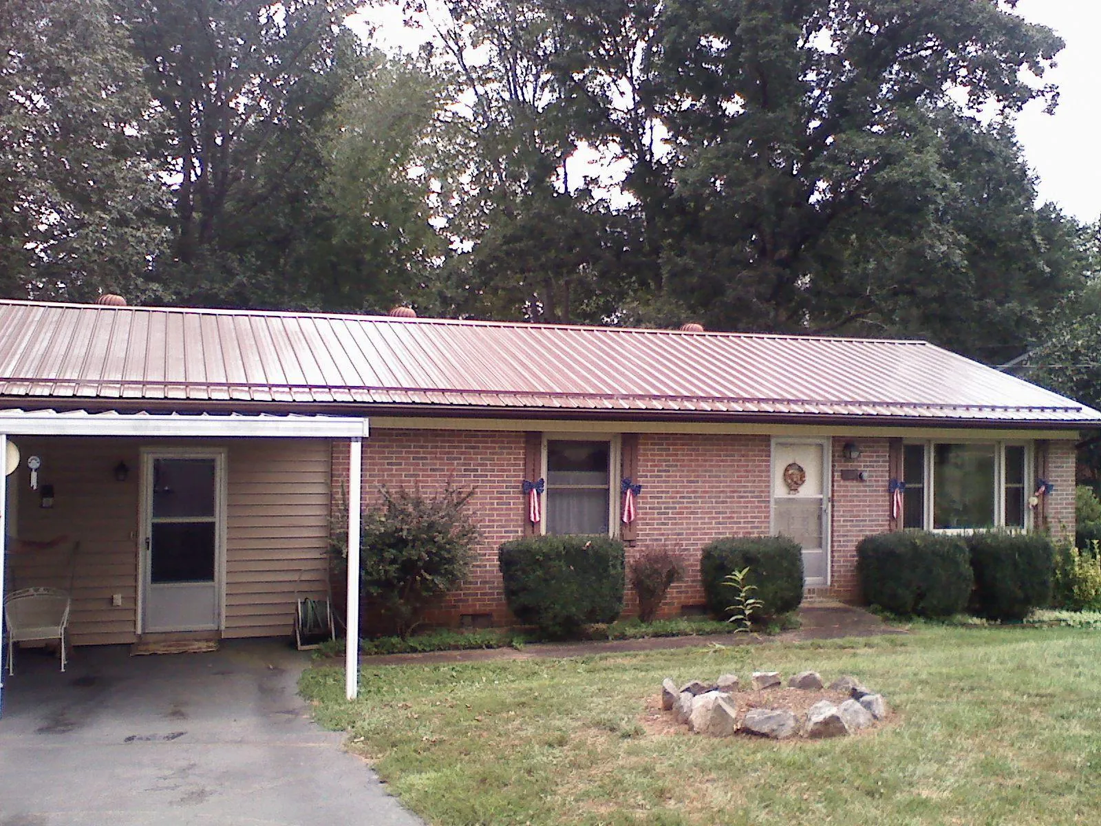 Bronze metal roof and carport on a brick ranch home — Roof Repair work by our crew in Tiverton